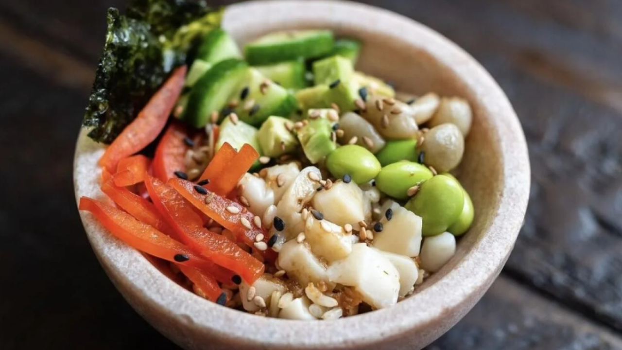 A bowl with various vegetables and rice as well as seaweed and cultivated protein