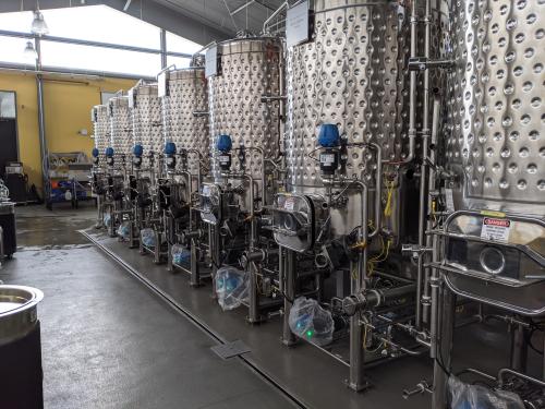 Seven silver fermentation tanks in a row