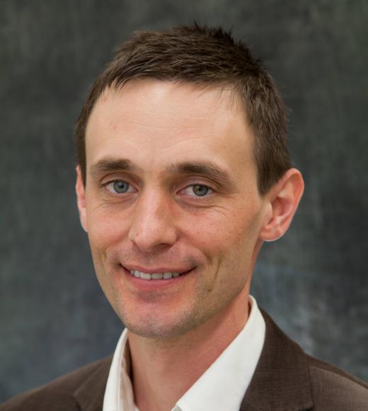 Professor Adam Moule against a gray backdrop