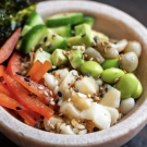 A bowl with various vegetables and rice as well as seaweed and cultivated protein